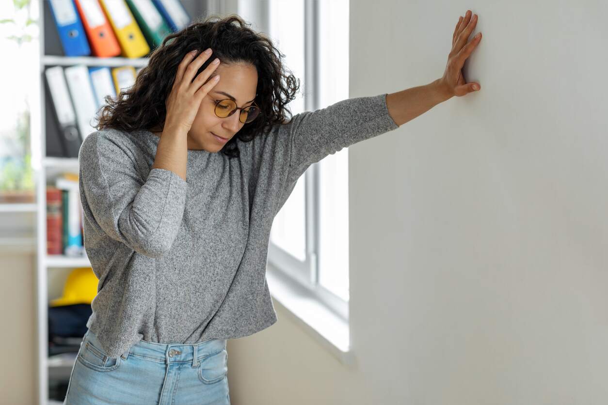 Woman with PPPD leaning against the wall