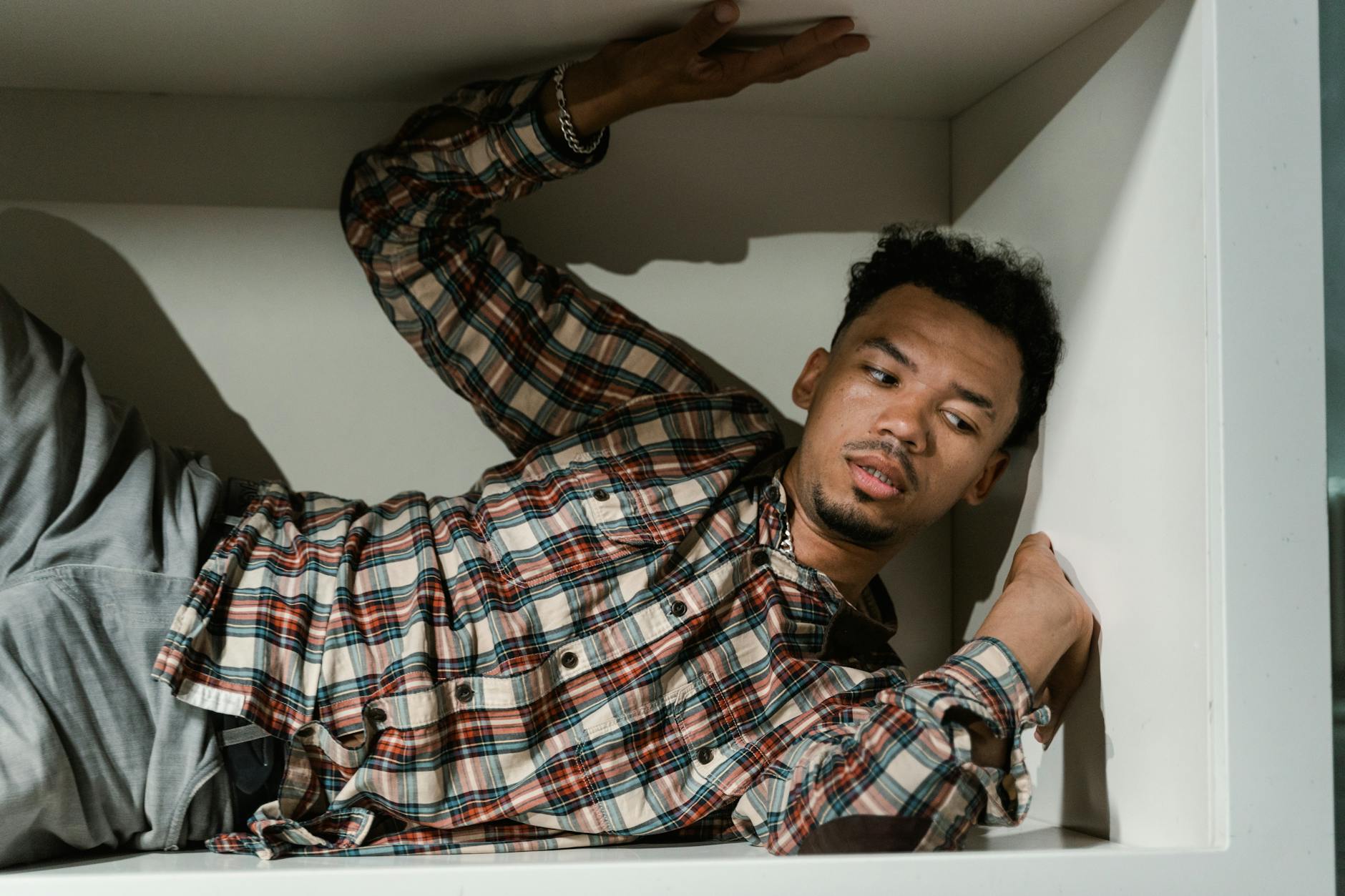 a fearful man having claustrophobia in a cabinet