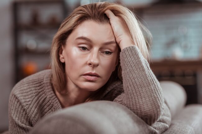 woman struggles to stop her intrusive thoughts, appears exasperated