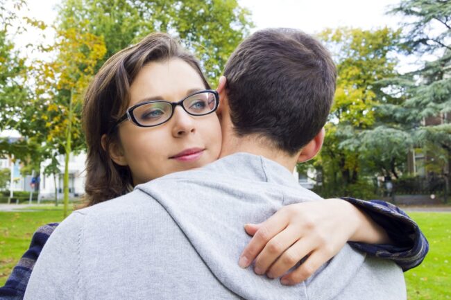 Woman using opposite action hugs her boyfriend